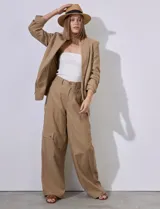 Blazer blanco de lino con cuello con solapa, bolsillos sastre y mangas fruncidas.