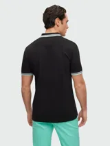 Remera polo roja de algodón, corte regular fit, con cuello y mangas con ribetes en blanco y marrón. Logo de la marca bordado en blanco en el pecho.