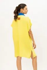 Camisa-vestido en algodón de muselina color amarillo con botones frontales y cuello azul.