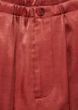 Pantalón color ladrillo de tiro alto, corte recto y tejido satinado.