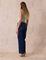 Jean de pierna ancha, color azul oscuro, con pretina con pasadores, botón y cierre. Delantera y trasera con bolsillos.