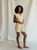 Chaleco color amarillo pálido con escote en V y sisas con terminación desflecada.