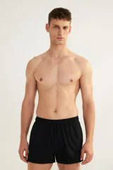 Short de baño negro de sirsaca con aberturas laterales cortas, cintura elástica con cordón ajustable, bolsillos laterales y bolsillo trasero con cierre autoadherente. Tiene suspensor interior de malla.