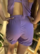 Short de tela liviana, color lila, con cintura elástica y bolsillos laterales.