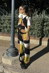 Pantalón largo de tejido jacquard con estampado geométrico en tonos negro, marrón, amarillo y blanco.