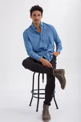 Camisa azul de manga larga con cuello abotonado.