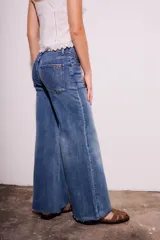 Pantalón de jean de tiro medio, color celeste, corte flared y wide leg.