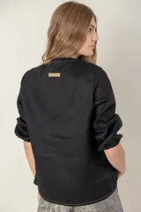 Camisa de jean celeste con cuello mao, abotonada al frente y mangas 3/4 con puños elásticos.