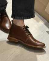 Botas acordonadas marrones de cuero vacuno con suela clara.