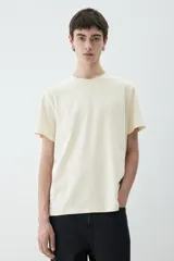 Remera de punto liviano color crema, con cuello redondo ribeteado y bajo recto. Corte estándar. Confeccionada con tejido funcional COOLMAX®, una fibra exclusiva de poliéster de secado rápido que elimina la humedad y regula la temperatura corporal.