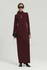 Vestido largo de microfibra con elastano, de ajuste al cuerpo y manga larga, con cuello alto y escote abierto en la espalda.
