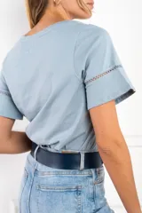 Remera celeste de algodón peinado, con cuello redondo y mangas cortas con detalle de calado.