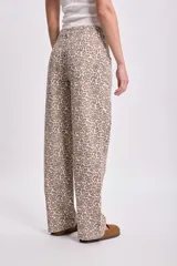 Pantalón de jean de corte recto con estampado animal print en tonos beige y marrón.