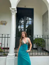 Vestido largo negro con escote en V, cut outs laterales bajo el busto y breteles finos cruzados y atados en la espalda.