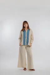 Camisa color beige con solapas y cierre con botones.