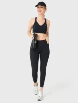 Calza deportiva negra con corte a la altura del tobillo, cintura alta con diseño en V y bolsillos laterales.