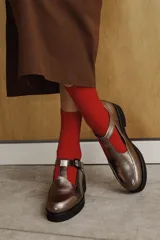 Zapato guillermina color bronce con acabado charol, suela de goma negra y plataforma.