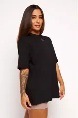 Remera negra de algodón sustentable, corte oversized, con cuello redondo y mangas cortas. Estampado frontal pequeño con la frase "pace your race".