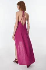 Conjunto de top halter con abertura en el abdomen y falda cruzada con ruedo desflecado, color fucsia.