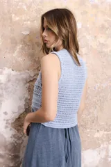 Chaleco corto tejido a crochet color verde oliva, con escote en V y cierre frontal con lazos.