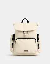 Mochila color beige con detalles en negro. Tiene solapa con tira de ajuste y broche, correas regulables, manija superior, bolsillo frontal con cierre y puller de cordón y goma, bolsillos laterales con cierres y pullers de cordón y goma, y tag de goma.