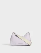 Bandolera color lila con correa ancha de tela color crema y tag frontal con texto en relieve.