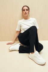 Pantalón negro de punto, corte suelto, con elástico en la cintura y aberturas en el ruedo.