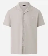 Camisa verde oscuro de piqué texturizado, con cuello solapa, abotonadura frontal, manga corta y bolsillo de parche en el pecho.