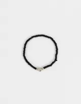 Pulsera elástica de mostacillas negras con dije de corazón plateado.