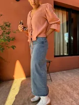 Blusa color salmón con escote en V y mangas 3/4 abullonadas con puños elásticos.