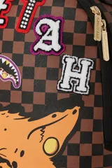 Mochila Sprayground en colaboración con el jugador de la NFL Tyreek Hill. Diseño con estampado a cuadros en tonos marrones y aplique de la cara de un guepardo.