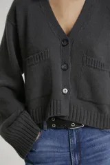 Cárdigan gris de tejido de punto con bolsillos delanteros y mangas anchas.