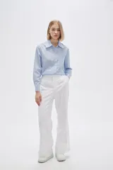 Pantalón de lino color beige, de corte recto y tiro alto, con bolsillos laterales.