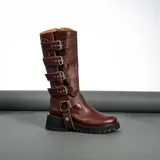 Bota de caña alta color marrón, confeccionada 100% en cuero vacuno. Cuenta con cierre YKK en el lateral interno, hebillas ajustables en el lateral externo, estribo desmontable y detalle trenzado a mano en el talón. La suela es de goma artesanal.