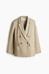 Blazer largo color beige de doble botonadura, con solapas de muesca, bolsillos delanteros ribeteados con solapa y forro interior.