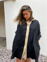 Camisa negra de lino con cuello clásico, cierre frontal con botones color beige y mangas 3/4 con trabillas.