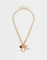Collar dorado con cadena de eslabones grandes y dijes colgantes de corazón rojo, herradura y moño con strass.