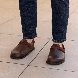 Zueco de cuero vacuno color negro, con suela de caucho, plantilla anatómica y tira con velcro en capellada y talón para mayor ajuste.