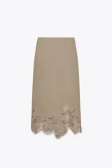 Falda midi color beige con bordado de flores en el ruedo.