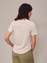 Remera color beige con cuello en V y mangas cortas.