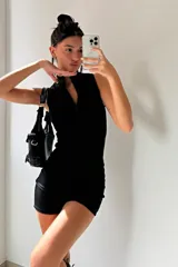 Mono corto negro ajustado al cuerpo, sin mangas y con cierre frontal.