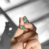Par de aros con forma de lágrima, con cristal color aguamarina y engarce dorado.
