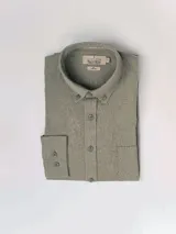 Camisa de manga larga azul, de lino y poliéster, con cuello abotonado y bolsillo en el pecho.