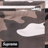 Short de baño Supreme con estampado de camuflaje en tonos blanco, gris y negro. Cuenta con cintura elástica, bolsillos laterales y bolsillos cargo con logo de la marca en el lateral.