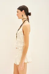 Musculosa color crema con breteles finos, escote en V y confeccionada en encaje floral forrado.