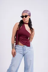 Top color borgoña con escote halter asimétrico y tiras finas que se atan al cuello.