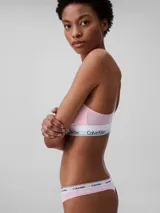 Conjunto Calvin Klein de ropa interior deportiva, compuesto por un corpiño con espalda racerback y una colaless, ambos en color rosado con elástico blanco con el logo de la marca.