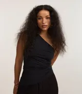 Blusa de jersey color negro con escote de un solo hombro, con franzidos laterales y bajo asimétrico.