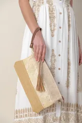 Sobre de mano de rafia color beige con diseño de franjas horizontales en tonos naturales. Incluye lazo de mano y correa desmontable para colgar.