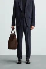Pantalón de vestir azul marino, de corte slim fit, confeccionado en tejido con 17% de lana. Cuenta con bolsillos frontales y traseros de doble vivo con botón. Cierre frontal con cremallera y botón.